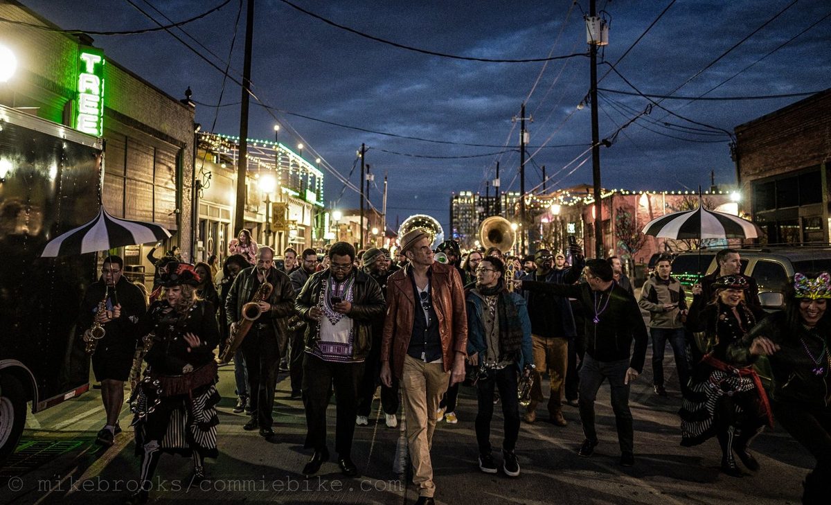 The Free Loaders in a night second-line parade through Deep Ellum, with tuba, sax and costumed dancers